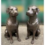 A PAIR OF BRONZED GARDEN ORNAMENTS in the form of two seated dogs, 75cm high approx.