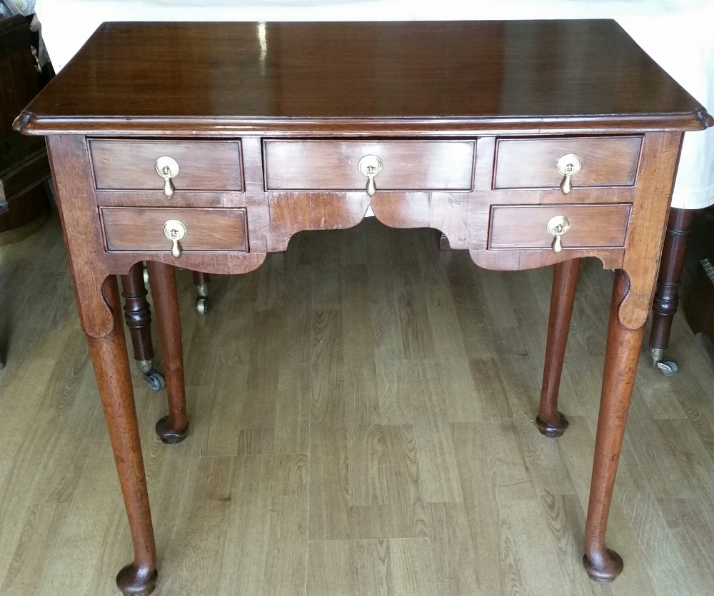 A VERY FINE GEORGE III MAHOGANY LOWBOY, with moulded top over a front shaped apron with five cock