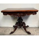 A LATE 19TH CENTURY ROSEWOOD FOLD OVER CARD TABLE, with rounded front corners, a shaped and carved