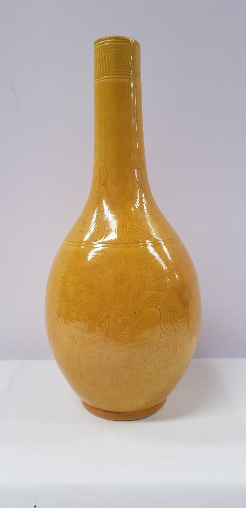 A YELLOW-GLAZED INCISED DRAGON BOTTLE VASE, decorated with images of dragons to the body and