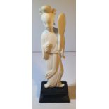 A 19TH CENTURY CARVED IVORY OKIMONO FIGURE HOLDING A FAN, sitting on a wooden base, 12cm (H) x 3.8cm