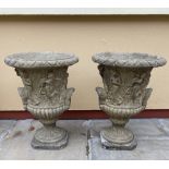 A PAIR OF STONE URNS, decorated with figures, 56cm tall approx.