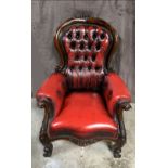 A GOOD LEATHER BUTTON BACKED LIBRARY CHAIR, with carved floral design to the frame and legs, real