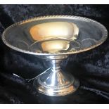 A SILVER TAZZA DISH, with gadrooned rim, raised on a pedestal base, stamped, 6 inches x 8 inches (