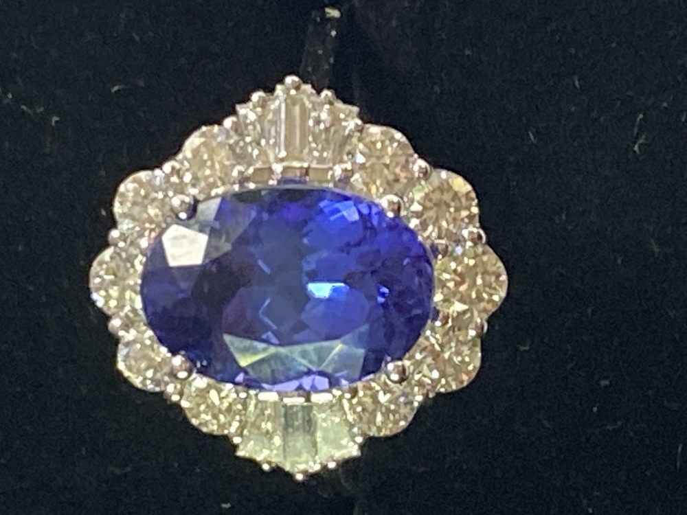 AN 18CT WHITE GOLD ART DECO STYLE TANZANITE AND DIAMOND CLUSTER RING, the superb oval shaped