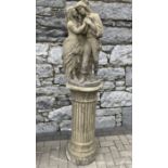 A GARDEN ORNAMENT IN THE FORM OF A ROMEO AND JULIET STATUE, standing on a pillar, approx. 6ft tall