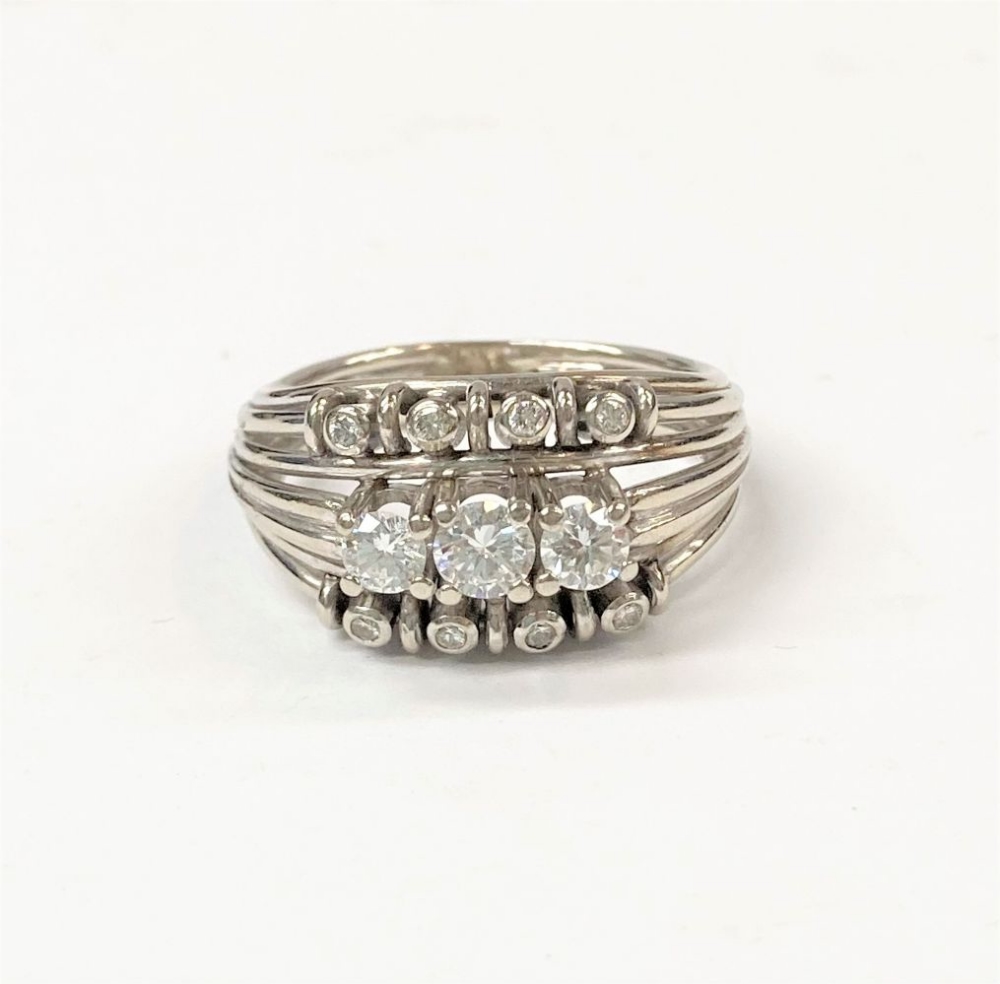 A 14 CARAT WHITE GOLD DIAMOND RING, split shank design with 3 large diamonds to centre, four smaller