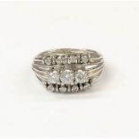 A 14 CARAT WHITE GOLD DIAMOND RING, split shank design with 3 large diamonds to centre, four smaller