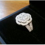 A STUNNING 18CT WHITE GOLD DIAMOND CLUSTER RING, in the form of a flower, main stone, brilliant cut,