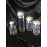 A SET OF 4 CUT GLASS SILVER TOPPED DRESSING TABLE CONTAINERS, each with silver collar and top,