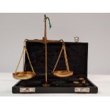 A CASED POLISHED BRASS INDIAN SCALES SET, with weights ranging from 10g to 1g, 18.5cm x 10cm x 3cm