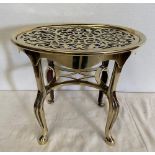 A VICTORIAN POLISHED BRASS FIRE TRIVIT OR STAND, with an Isle of Man symbol to the centre of the