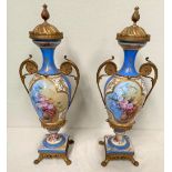 A PAIR OF SEVRES PORCELAIN URNS, decorated with floral picture panels, with ormolu mounts and lid,