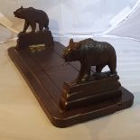 AN EARLY 20TH CENTURY CARVED BLACK FOREST TABLE TOP BOOKSLIDE, each collapsible end decorated with