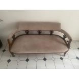 A LATE 19TH / EARLY 20TH CENTURY THREE SEATER COUCH, with curved back and arm rests, raised on 5 sho