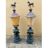 A PAIR OF CAST ALLOY PIER CAP LIGHTS / LANTERSN, with copper tops, topped with a horse decoration, 1