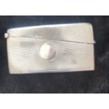 A SOLID SILVER CARD CASE, Birmingham, 1906, with vacant central cartouche and radiating rising sun d