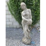 A STONE GARDEN ORNAMENT IN THE FORM OF A FEMALE FIGURE, holding an urn, size: 4ft tall approx.