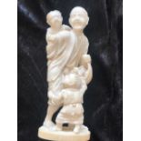 AN IVORY CARVED OKIMONO, depicting a Father with his two playful children. With stamp to base. Appro