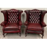 A MATCHING PAIR OF WING BACKED LEATHER ARM CHAIRS, each with deep button backs and barley twist deta