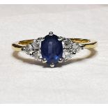 AN 18CT YELLOW GOLD OVAL CUT SAPPHRIE AND DIAMOND RING, with central oval sapphire flanked by three