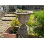 AN UNUSUAL STONE GARDEN URN on plinth with drapery decoration, 28in high