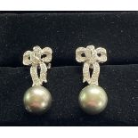 A PAIR OF TAITHAN PEARL AND DIAMOND DROP EARRINGS, with elegant ribbon setting for the diamonds abov
