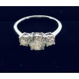 AN 18CT WHITE GOLD THREE STONE DIAMOND RING, with a larger central raised diamond flanked by a small