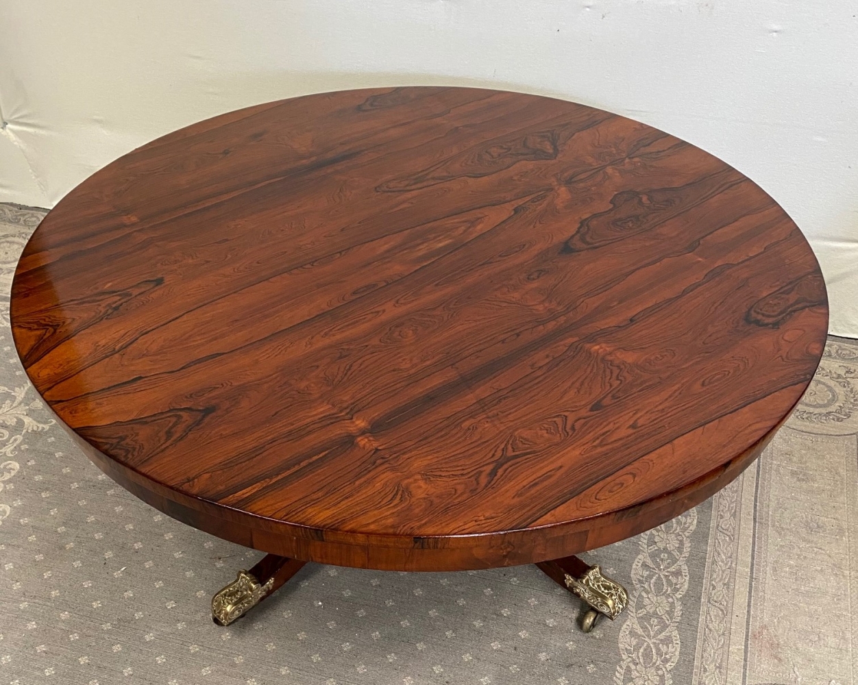 A GOOD QUALITY REGENCY ROSEWOOD CIRCULAR COFFEE TABLE, raised on a short turned column support with