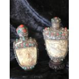TWO CHINESE HAND CARVED IVORY SNUFF BOTTLES, with tinted ivory bead decoration on white metal body.