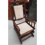 AN EARLY 20TH CENTURY ROCKING CHAIR, with carved decoration to the back support, and ring turned spi