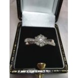 A STUNNING 9CT WHITE GOLD DIAMOND CLUSTER ENGAGEMENT RING, with elegant cross-over design, ring size