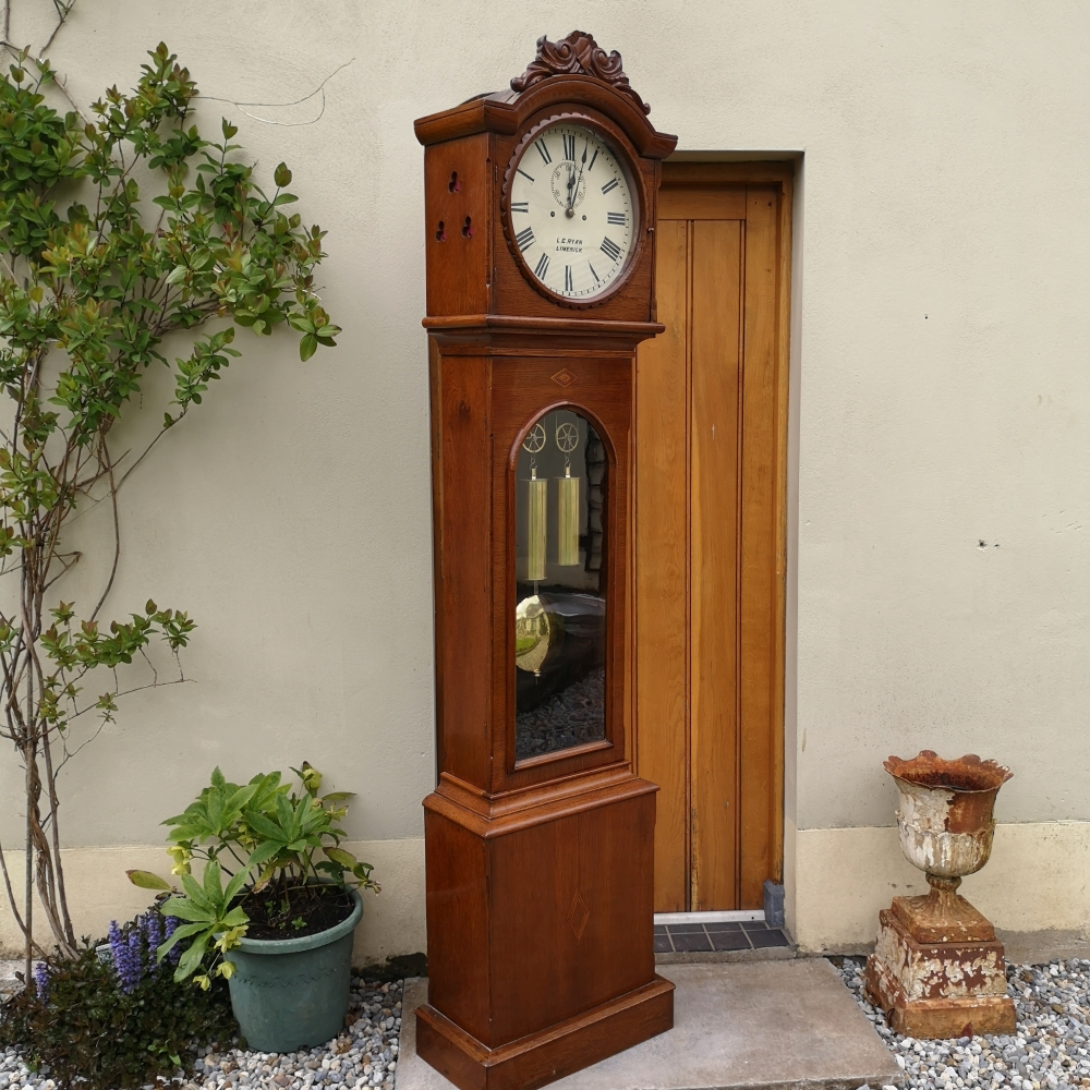 A VICTORIAN OAK CASED PROVINCIAL DOMESTIC REGULATOR GRANDFATHER CLOCK, name on the clock face: L. E.