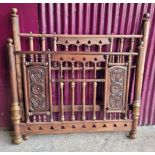 A WOODEN BED FRAME, with head and end, hand carved panels to the end, with turned spindles to head a