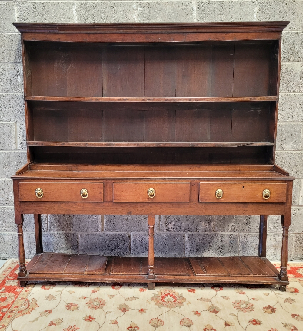 AN 18TH CENTURY OAK SIDE BOARD/ DRESSER, with raised shelved back, each shelf with plate lip and ree