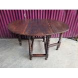 AN ANTIQUE OAK DROP LEAF TABLE, Jacobean style, with bobbin turned legs, double gate leg, 93 x 70 x