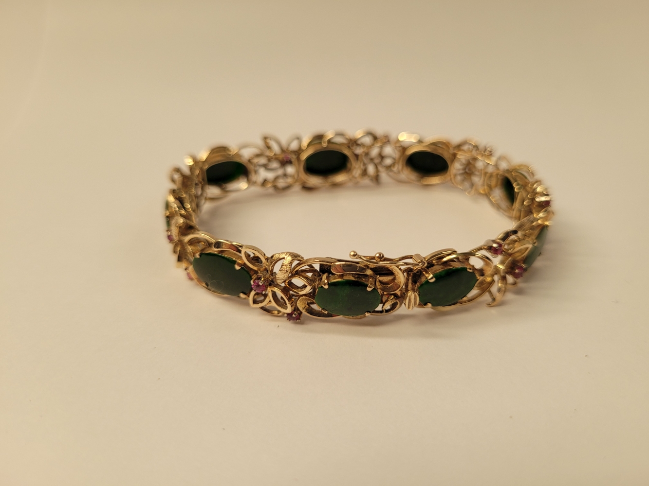 A 14CT YELLOW GOLD JADE AND RUBY BRACELET, 19cm long. Floral design setting. Marked 585 14K. - Image 6 of 7