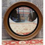 A LARGE CIRCULAR GILT WALL MIRROR, with ebonised slip, gently concave glass. 81cm x 80cm approx