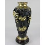 A Japanese bronze vase of baluster form decorated with applied grapes and vine leaves, marks to