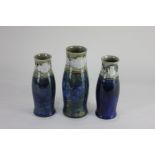 A single and matching smaller pair of Royal Doulton stoneware vases baluster form with blue