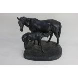 A Russian Kasli cast iron model of a mare and suckling foal standing on a plinth base,