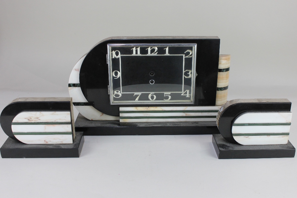An Art Deco marble three piece clock garniture, possibly French, with green and white striped