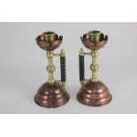 A pair of Christopher Dresser for Benham and Froud brass and copper candlesticks with turned wood