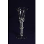 An 18th century style wine glass, the funnel bowl on air twist stem with central knop, on conical