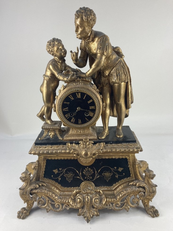 A 19th century gilt figural mantle clock, the circular black and gilt face, marked Philippe, the