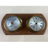 A Sestrel brass cased bulkhead barometer and alarm clock on wooden mount, 23.5cm wide