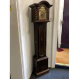 An oak grandmother clock with brass dial in arched case with turned supports and panelled door,