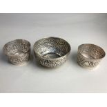 An Indian silver circular bowl embossed with animals in a forest, 9cm and a pair of small circular