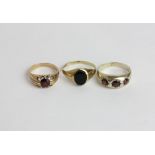 A garnet single stone ring in 9ct gold; a garnet ring in silver, and a black onyx signet ring in 9ct