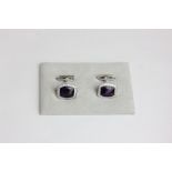 A pair of amethyst and diamond cufflinks the cushion cut cabochon in a diamond border